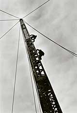workers climb a construction tower