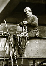 a steel worker sits on a beam 