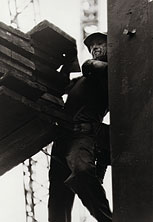 A steelworker squeezes into a tight space