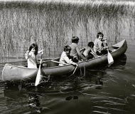 Children playing in a canoe, Nett Lake, MN.